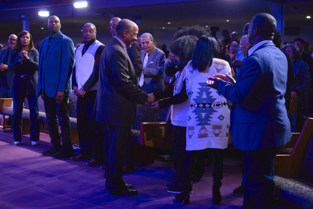 Congregation member shaking hands with Bishop David G. Evans during a church service, representing community and how to bounce back in life through faith. www.go2bethany.com