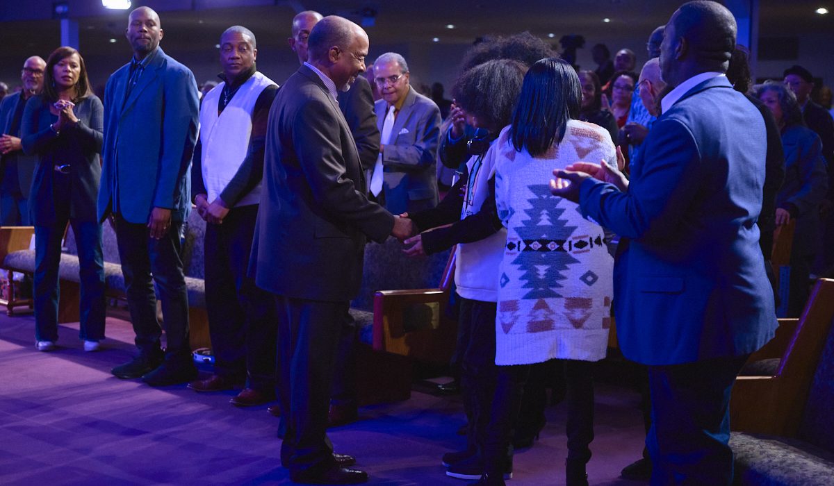 Congregation member shaking hands with Bishop David G. Evans during a church service, representing community and how to bounce back in life through faith. www.go2bethany.com